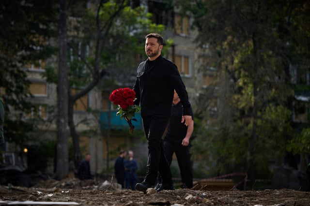 Ukraine's President Volodymyr Zelenskiy carries flowers to pay tribute to victims, who were killed during Russian drone and missile strikes on Tuesday, at the site of a damaged apartment building, amid Russia's attack on Ukraine, in Kyiv, Ukraine June 19, 2025. Ukrainian Presidential Press Service/Handout via REUTERS/File Photo