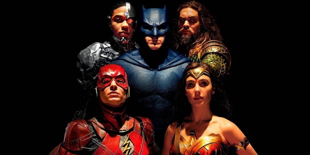 The cast of Justice League looking at the camera with a black background.