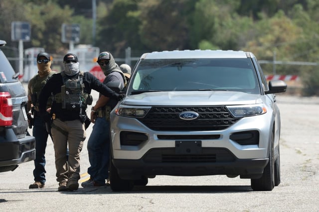 Federal agents stage outside Gate E of Dodger Stadium in Los Angeles, Thursday, June 19, 2025. (Myung J. Chun/Los Angeles Times via AP)
