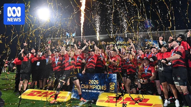 A rugby team celebrates wnning a grand fnal