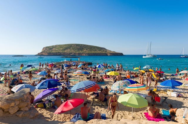 Bañistas disfrutan en la Cala Conta, en Ibiza, Baleares (España).