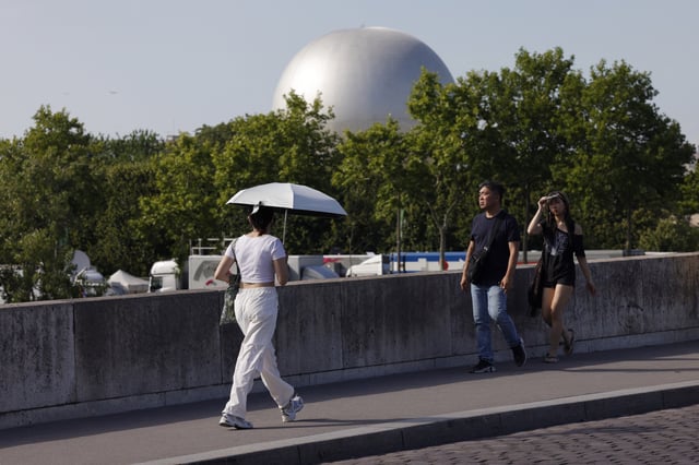 Des touristes bravent la chaleur à Paris le 21 juin 2025.