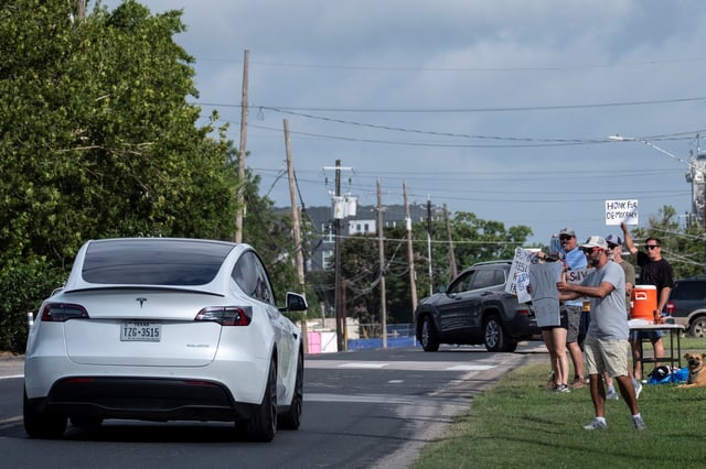 Demonstrators protest against Tesla and its CEO Elon Musk, outside a Tesla service center and gallery in Austin, Texas, U.S., June 21, 2025.    REUTERS/Joel Angel Juarez