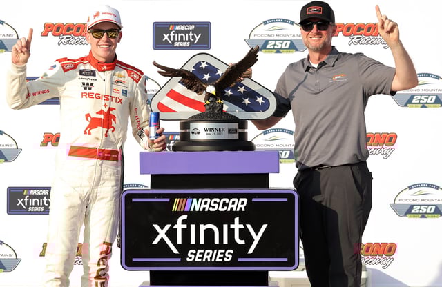 Connor Zilisch, driver of the #88 Registix Chevrolet, and JR Motorsports team owner, and fill-in crew chief Dale Earnhardt Jr. celebrate in victory lane after winning the NASCAR Xfinity Series Explore the Pocono Mountains 250 at Pocono Raceway on June 21, 2025 in Long Pond, Pennsylvania.