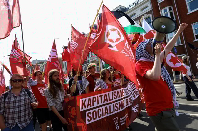Demonstrators hold 'ROOD Socialistische Jongeren' (RED socialist youth) flags during a march against the upcoming NATO leaders' summit, at The Hague, Netherlands, June 22, 2025. REUTERS/Piroschka van de Wouw
