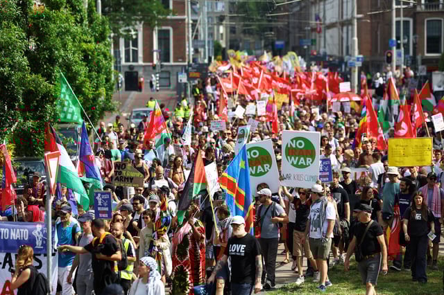 Demonstrators hold signs against a war in Iran, during a march against the upcoming NATO leaders' summit, at The Hague, Netherlands, June 22, 2025. REUTERS/Piroschka van de Wouw