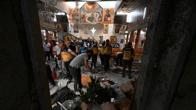 People and rescuers inspect the damage at the site of a reported suicide attack at the Saint Elias church in Damascus' Dwelaa area on June 22, 2025.