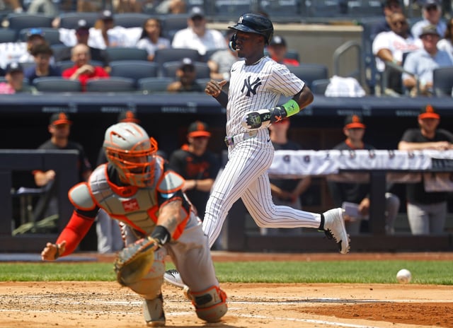 New York Yankees Jazz Chisholm Jr. scores a run in front of Baltimore Orioles catcher Gary Sánchez during the third inning of a baseball game, Saturday, June 21, 2025, in New York. (AP Photo/Noah K. Murray)