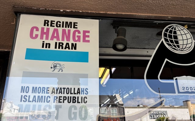 A sign calling for the overthrow of the Islamic government in Iran is placed behind glass in a bookstore in an Iranian-American area of Los Angeles, California, U.S., June 22, 2025. REUTERS/Tim Reid