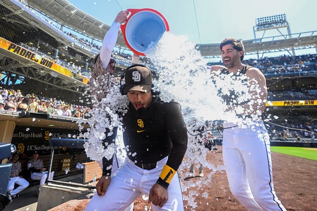 Jun 22, 2025; San Diego, California, USA; San Diego Padres second baseman Jose Iglesias (7) has ice poured over him by Jackson Merrill (3), left, and Tyler Wade (14) after hitting a walk-off fielder’s choice during the ninth inning against the Kansas City Royals at Petco Park. Mandatory Credit: Denis Poroy-Imagn Images