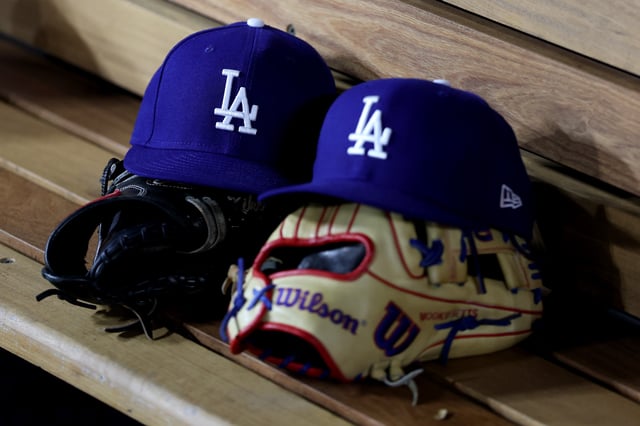 LOS ANGELES, CALIFORNIA - MARCH 31: A detailed view of Los Angeles Dodgers hats and gloves during the game against the Atlanta Braves at Dodger Stadium on March 31, 2025 in Los Angeles, California.