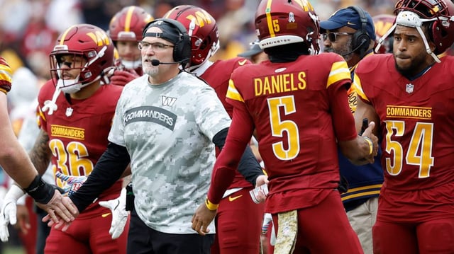 Washington Commanders head coach Dan Quinn (L) and quarterback Jayden Daniels (5)