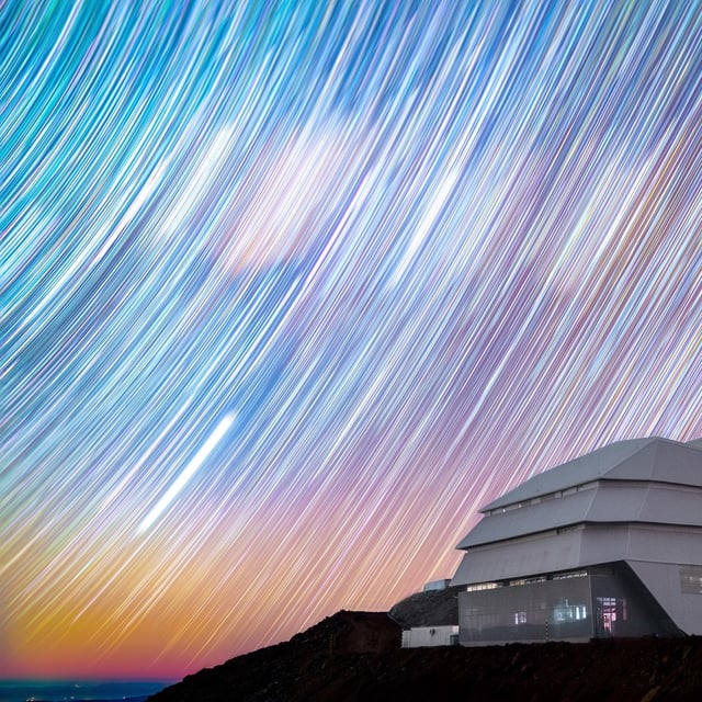 Star trails appear as colorful brushstrokes spread across the night sky above NSF-DOE Vera C. Rubin Observatory.