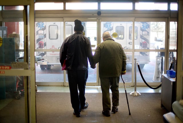 In this 2014 photo, a patient is assisted while walking out of the emergency department at a hospital in Atlanta.