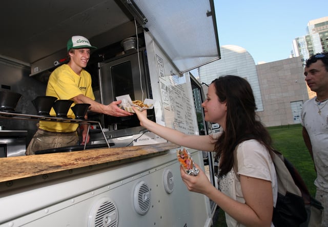 (083110 Boston, MA) Shauna Galante from Boston picks up some fries and a sandwich from Bobby Duddy working the “Clover” food truck parked in Dewey Square near South Station, August 31, 2010, Boston, MA. (Staff photo by John Wilcox) (Photo by John Wilcox/MediaNews Group/Boston Herald via Getty Images)

