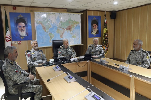 In this photo released on Monday, 23, 2025, by Iranian army press service, Iran's army commander-in-chief Gen. Amir Hatami, center, accompanied by high ranked army commanders, speaks in a video call with top commanders of the army, in Zolfaghar central headquarters, Iran, as portraits of the late revolutionary founder Ayatollah Khomeini, left, and Supreme Leader Ayatollah Ali Khamenei hang on the wall. 