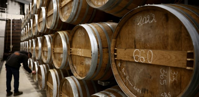 Des fûts de cognac dans la cave d'un producteur à Jarnac-Champagne, le 20 mars 2025