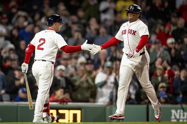 BOSTON, MASSACHUSETTS - MAY 20: Rafael Devers #11 of the Boston Red Sox reacts with Alex Bregman #2 of the Boston Red Sox after hitting a home run during the fifth inning against the New York Mets at Fenway Park in Boston, Massachusetts.