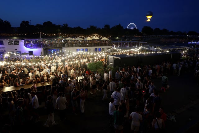 People attend France's annual street music festival, the Fete de la Musique, on the Seine river banks in Paris on June 21, 2025.