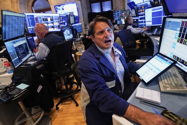 Trader Micheal Milano, right, works with colleagues on the floor of the New York Stock Exchange, Monday, June 23, 2025. (AP Photo/Richard Drew)