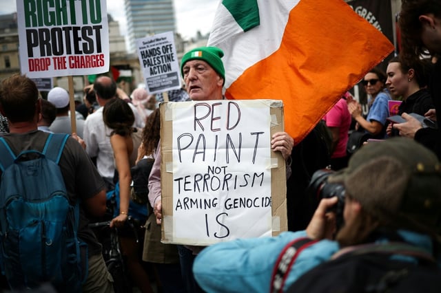 Un manifestant tient une pancarte "De la peinture rouge, pas du terrorisme, l'armement est un génocide" lors d'un rassemblement en soutien au groupe pro-palestinien Palestine Action, alors que le gouvernement britannique devrait annoncer l'interdiction du groupe, le 23 juin 2025 à Londres