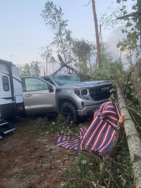 Fallen trees are shown near a truck and camper in Samuel de Champlain Provincial Park near Mattawa, Ont., after weekend storm in this handout photo.