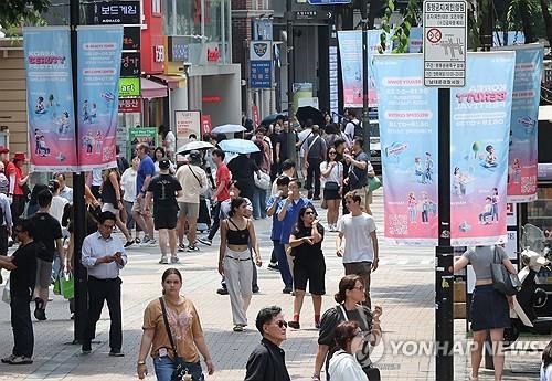 This file photo, taken June 19, 2025, shows people walking along a street in Myeongdong in central Seoul. (Yonhap)