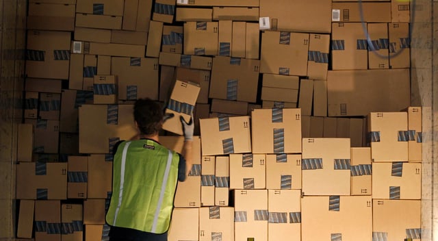 A worker stacks a shipping trailer with boxed items for delivery at Amazon's distribution center in Phoenix, Arizona November 22, 2013.  REUTERS/Ralph D. Freso/File Photo