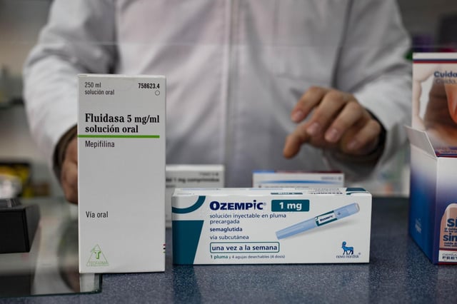 Un farmacéutico dispensa varios medicamentos a un paciente en una foto de archivo.