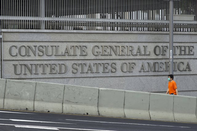 FILE - A man walks past U.S. Consulate in Hong Kong, March 15, 2021. (AP Photo/Vincent Yu, File)