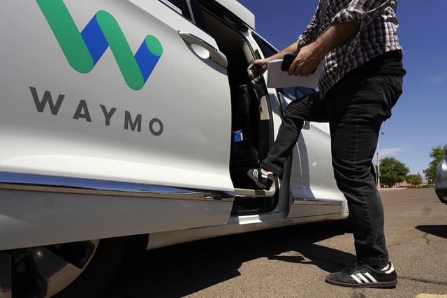 FILE - A Waymo minivan arrives to pick up passengers for an autonomous vehicle ride, April 7, 2021, in Mesa, Ariz. (AP Photo/Ross D. Franklin, File)