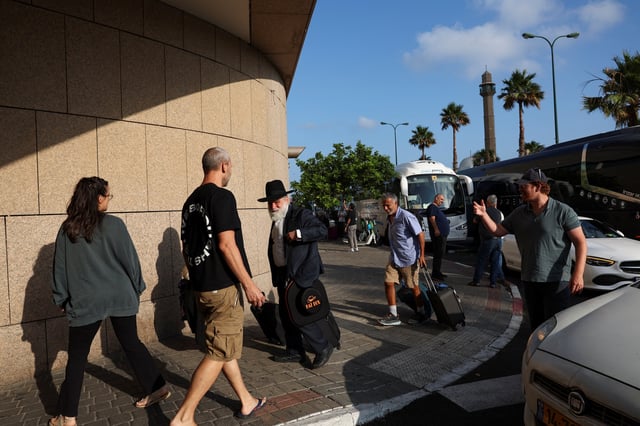 Australian nationals walk to board a bus heading to Ben Gurion International airport for an evacuation flight to Australia, amid the Iran-Israel conflict, in Tel Aviv, Israel, June 24, 2025. REUTERS/Violeta Santos Moura