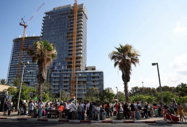Foreign nationals wait in line to board a bus to be evacuated from Israel, amid the Iran-Israel conflict, in Tel Aviv, Israel, June 24, 2025. REUTERS/Violeta Santos Moura