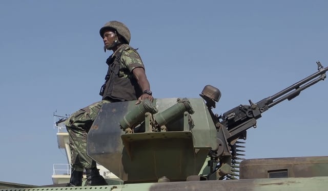 FILE - In this image made from video, a Mozambican soldier rides on an armored vehicle at the airport in Mocimboa da Praia, Cabo Delgado province, Mozambique, Aug. 9, 2021. (AP Photo/Marc Hoogsteyns, File)