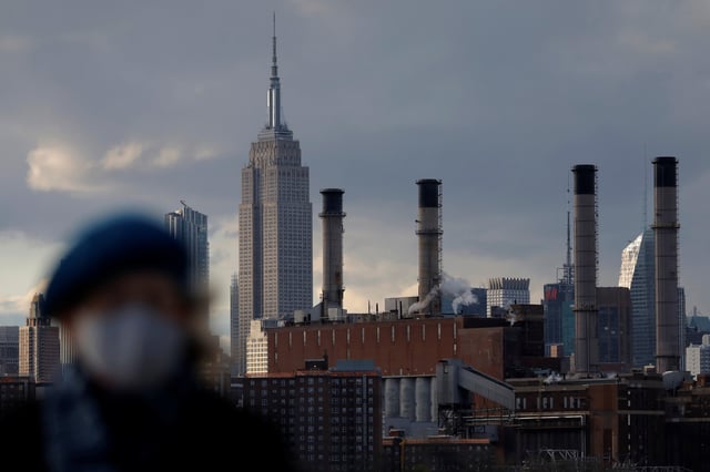 A person walks in front of the Con Edison Power Plant in Manhattan, New York City, New York, U.S., April 22, 2021. REUTERS/Andrew Kelly/File Photo