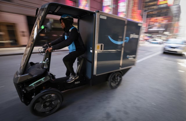 An Amazon.com delivery worker rides a four-wheel electric cargo delivery vehicle in Manhattan in New York City, U.S., March 19, 2025. REUTERS/Mike Segar/File Photo