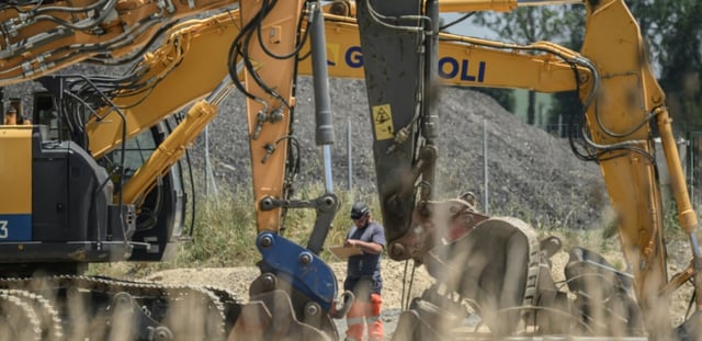 Un ouvrier se tient à côté de pelles mécaniques sur le chantier de l'autoroute A69 près de Verfeil, dans le Tarn-et-Garonne, le 17 juin 2025