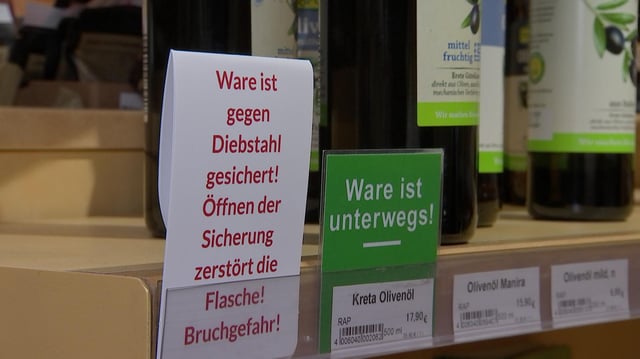 Ein Schild an einem Regal in einem Supermarkt weist darauf hin, dass die Ware gegen Diebstahl gesichert ist.