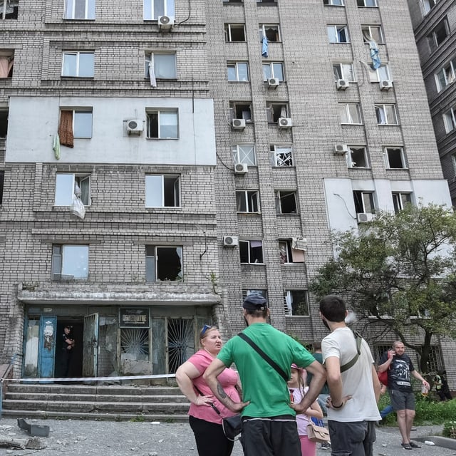 Residents stand near an apartment building that was damaged during a Russian missile strike, in Dnipro, Ukraine, June 24.