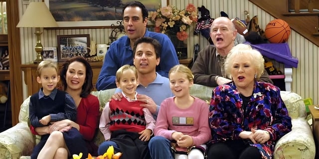 Cast of Everybody Loves Raymond sitting around family couch.