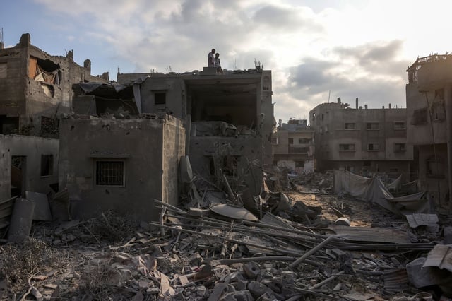 Palestinians standing atop a building after an Israeli strike west of Jabalia in the northern Gaza Strip on June 23.