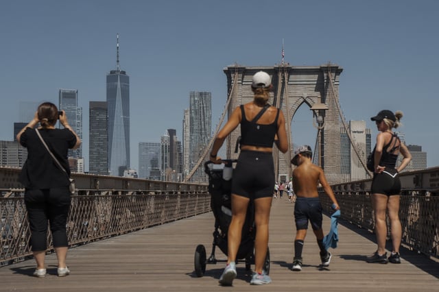 People cross the Brooklyn Bridge during a heatwave on Tuesday, June 24, 2025, in New York. (AP Photo/Olga Fedorova)