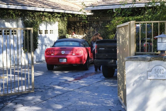 FILE - An unknown visitor arrives at a gated house in the Woodland Hills section of Los Angeles on Tuesday, Jan. 24, 2017, where homicide detectives are investigating the death of Fabio Sementilli. (AP Photo/Richard Vogel, File)