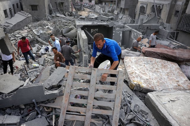 Palestinians search for survivors from the rubble of a home that was hit by an Israeli strike, west of Jabalia, in northern Gaza on June 23.