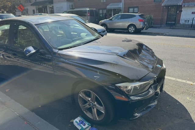 The dented BMW on which a witness says Amanda Servedio landed after the pickup truck driver struck her.