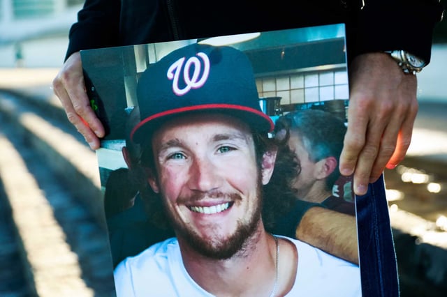 Sean Riley stands for a portrait while holding a photograph of his slain son Calvin Riley at Aquatic Park near Ghiradelli Square at the same spot where his son was murdered in 2016 in San Francisco.