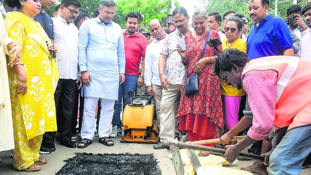 PWD workers fix a pothole on a road in the presence of Delhi PWD Minister Parvesh Sahib Singh Verma during the 24-hour pothole repair drive on Tuesday. (Vipin Kumar/Hindustan Times)