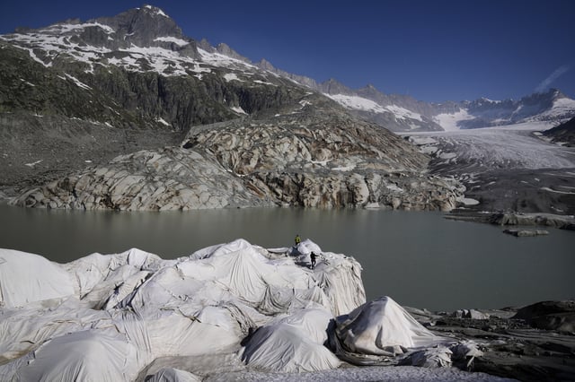 Workers prepare sheets to cover the Rhone Glacier near Goms, Switzerland, June 10, 2025. (AP Photo/Matthias Schrader)