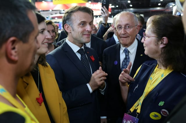 Le président français Emmanuel Macron se tient aux côtés du PDG du groupe La Poste, Philippe Wahl, et d'employés de La Poste au salon VivaTech, à Paris, le 11 juin 2025