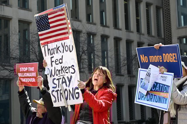 Protesters hold signs in solidarity with the American Federation of Government Employees of District 14 at a rally in support of federal workers at the Office of Personnel Management in Washington, DC, March 4, 2025.